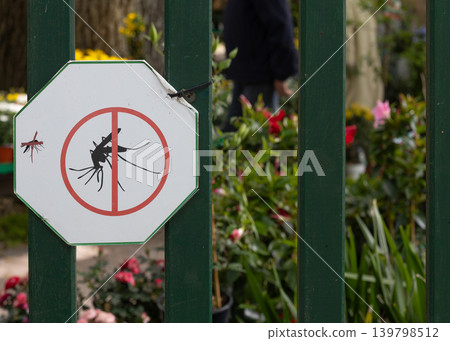 Anti mosquito warning sign on wooden fence 139798512