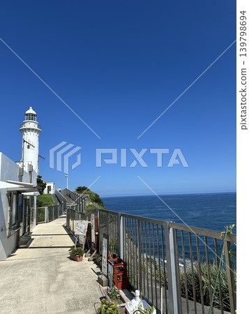 Scene of a white lighthouse against a clear blue sky Scene of a white lighthouse against a clear blue sky 139798694