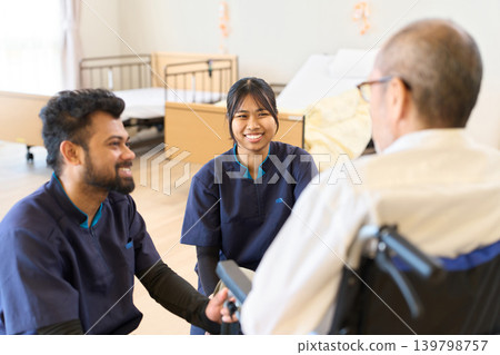 A foreign caregiver looks after a senior citizen in a wheelchair. A foreign caregiver looks after a senior citizen in a wheelchair. 139798757