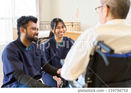 A foreign caregiver looks after a senior citizen in a wheelchair. A foreign caregiver looks after a senior citizen in a wheelchair. 139798758