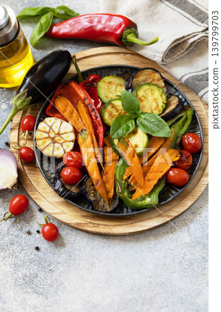 Grilled vegetables: red and yellow paprika, garlic, zucchini, eggplants, carrots on a stone tabletop. Summer homemade recipe. Copy space. Grilled vegetables: red and yellow paprika, garlic, zucchini, eggplants, carrots on a stone tabletop. Summer homemade recipe. Copy space. 139799703