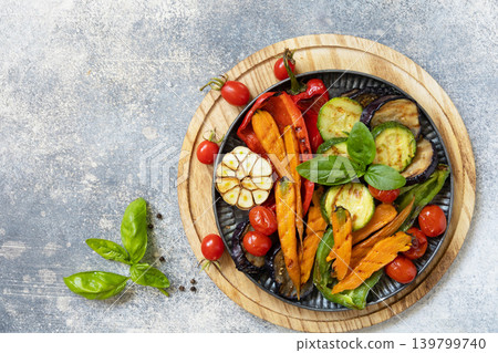Grilled vegetables: red and yellow paprika, garlic, zucchini, eggplants, carrots on a stone tabletop. Summer homemade recipe. View from above. Copy space. Grilled vegetables: red and yellow paprika, garlic, zucchini, eggplants, carrots on a stone tabletop. Summer homemade recipe. View from above. Copy space. 139799740
