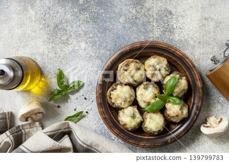 Keto stuffed mushrooms baked with cheese on a stone tabletop. View from above. Keto stuffed mushrooms baked with cheese on a stone tabletop. View from above. 139799783