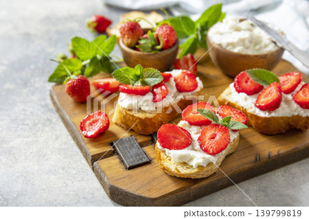 Bruschetta with ricotta and strawberry on a stone tabletop. Berries toast summer breakfast, healthy food. Copy space. 139799819