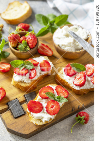 Bruschetta with ricotta and strawberry on a stone tabletop. Berries toast summer breakfast, healthy food. Bruschetta with ricotta and strawberry on a stone tabletop. Berries toast summer breakfast, healthy food. 139799820