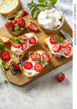 Bruschetta with ricotta and strawberry on a stone tabletop. Berries toast summer breakfast, healthy food. Copy space. 139799821