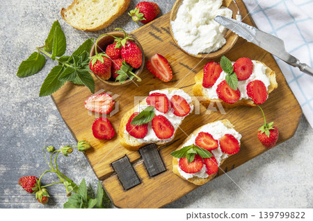 Bruschetta with ricotta and strawberry on a stone tabletop. Berries toast summer breakfast, healthy food. View from above. 139799822