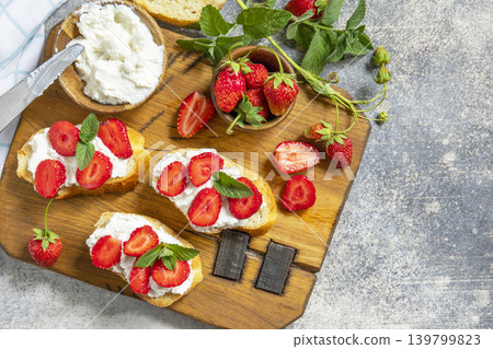 Bruschetta with ricotta and strawberry on a stone tabletop. Berries toast summer breakfast, healthy food. View from above. Copy space. Bruschetta with ricotta and strawberry on a stone tabletop. Berries toast summer breakfast, healthy food. View from above. Copy space. 139799823