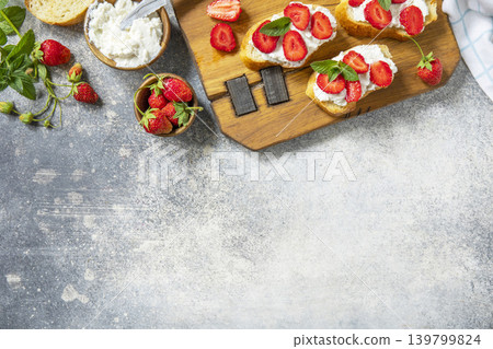 Bruschetta with ricotta and strawberry on a stone tabletop. Berries toast summer breakfast, healthy food. View from above. Copy space. Bruschetta with ricotta and strawberry on a stone tabletop. Berries toast summer breakfast, healthy food. View from above. Copy space. 139799824