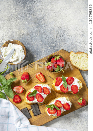 Bruschetta with ricotta and strawberry on a stone tabletop. Berries toast summer breakfast, healthy food. View from above. Copy space. 139799826