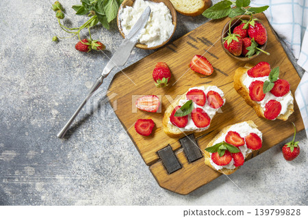 Bruschetta with ricotta and strawberry on a stone tabletop. Berries toast summer breakfast, healthy food. View from above. Copy space. 139799828