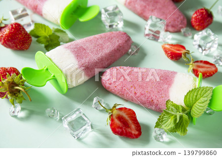 Refreshing Homemade strawberry ice cream or popsicles on soft green background. Refreshing Homemade strawberry ice cream or popsicles on soft green background. 139799860