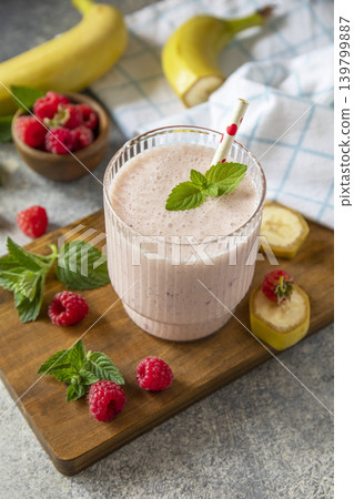 Pink raspberries and banana fruit smoothie or milk protein shake on stone tabletop. Yogurt cocktail, natural detox. Liquid ice cream. Copy space. Pink raspberries and banana fruit smoothie or milk protein shake on stone tabletop. Yogurt cocktail, natural detox. Liquid ice cream. Copy space. 139799887
