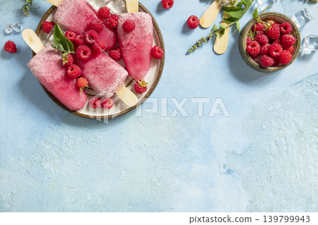 Healthy summer food concept, homemade raspberry ice cream. Vegan raspberry milk popsicles on a blue stone background. View from above. Copy space. Healthy summer food concept, homemade raspberry ice cream. Vegan raspberry milk popsicles on a blue stone background. View from above. Copy space. 139799943