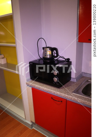Compact Kitchenette with Red Cabinets and Appliances 139800210