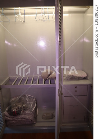 Closet Interior with Stored Items and Hangers Closet Interior with Stored Items and Hangers 139800217