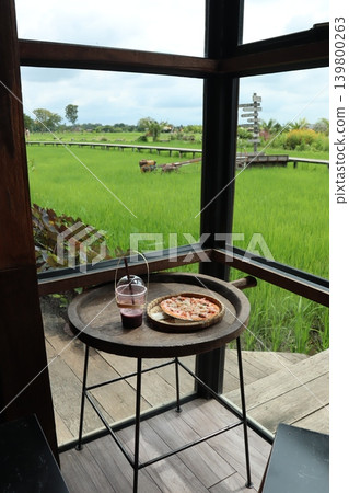 Glass House Dining View with Pizza and Drink Over Lush Green Field Glass House Dining View with Pizza and Drink Over Lush Green Field 139800263