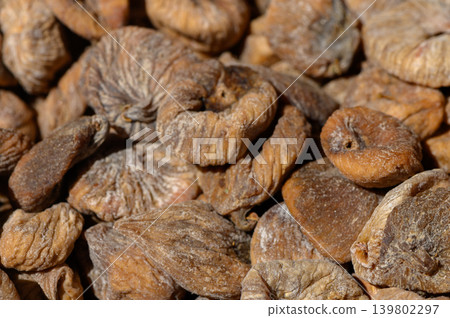 Dried figs displayed in sunlight highlighting their rich texture and natural sweetness in a vibrant marketplace Dried figs displayed in sunlight highlighting their rich texture and natural sweetness in a vibrant marketplace 139802297