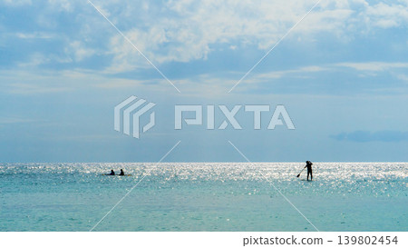在沖繩波光粼粼的大海上,人們享受著立式槳板和獨木舟的樂趣(夏季休閒景象) 在沖繩波光粼粼的大海上,人們享受著立式槳板和獨木舟的樂趣(夏季休閒景象) 139802454