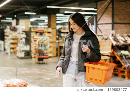 Young woman shopping for fresh produce in supermarket Young woman shopping for fresh produce in supermarket 139802477