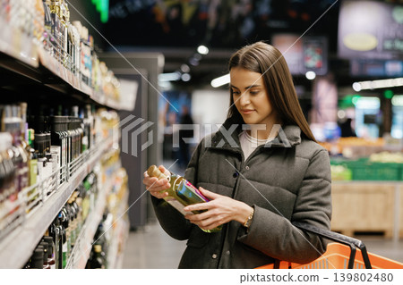 Woman choosing products from a supermarket shelf Woman choosing products from a supermarket shelf 139802480