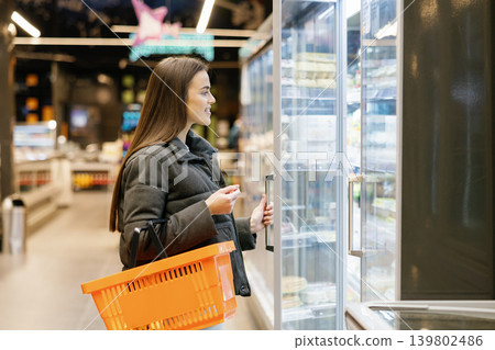 Woman shopping for frozen food in supermarket aisle 139802486