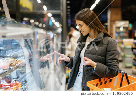 Woman choosing groceries in supermarket refrigerator display 139802490