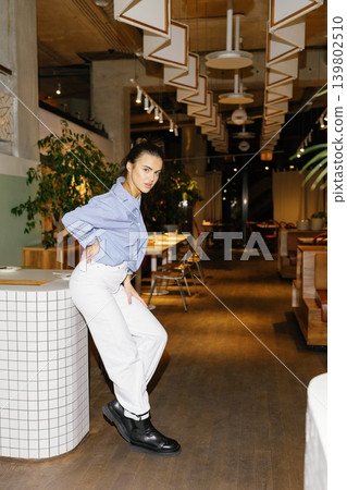 Smiling woman posing inside a modern restaurant 139802510