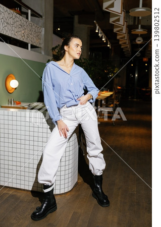 Woman posing in casual fashion outfit in restaurant 139802512