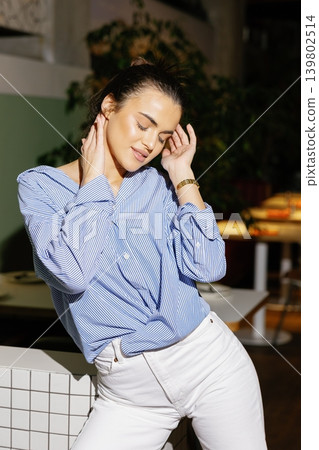 Woman posing in casual fashion outfit in restaurant Woman posing in casual fashion outfit in restaurant 139802514