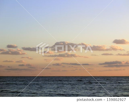 Clouds floating in the sunset sky and a calm seascape Clouds floating in the sunset sky and a calm seascape 139802927