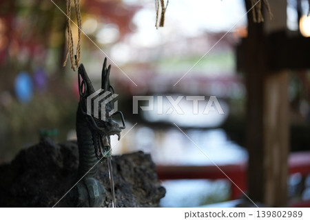 神社水池邊擺放著一座狐狸雕塑。 神社水池邊擺放著一座狐狸雕塑。 139802989