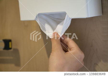 A woman's hand taking a mask out of a mask case. A woman's hand taking a mask out of a mask case. 139803649