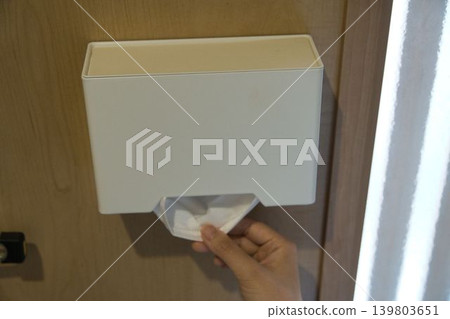A woman's hand taking a mask out of a mask case. A woman's hand taking a mask out of a mask case. 139803651