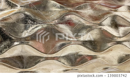 Luxury abstract golden metallic wave pattern with a reflective shiny surface in a macro view Luxury abstract golden metallic wave pattern with a reflective shiny surface in a macro view 139803742