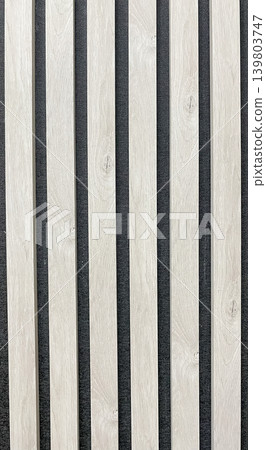 Minimalist background of light wood slats on a dark acoustic felt panel with a linear geometric pattern 139803747