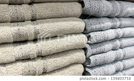 Neat stacks of soft beige and blue terry towels with woven patterns for modern bathroom styling Neat stacks of soft beige and blue terry towels with woven patterns for modern bathroom styling 139803758