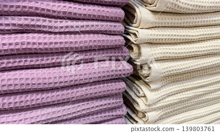 Stacks of purple and beige waffle weave cotton towels creating a textured aesthetic home display Stacks of purple and beige waffle weave cotton towels creating a textured aesthetic home display 139803761