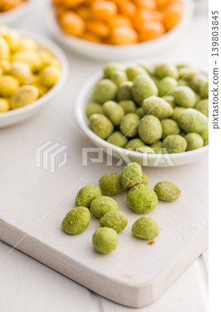 Crunchy Wasabi Peas And Colorful Snack Bowls On White Board. Spicy Green Snack Close-Up Crunchy Wasabi Peas And Colorful Snack Bowls On White Board. Spicy Green Snack Close-Up 139803845