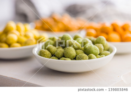 Crunchy Wasabi Peas And Colorful Snack Bowls On White Board. Spicy Green Snack Close-Up Crunchy Wasabi Peas And Colorful Snack Bowls On White Board. Spicy Green Snack Close-Up 139803846