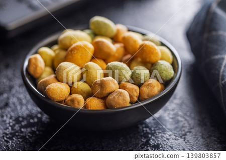 Close-Up Bowl of Coated Peanuts and Crunchy Snack Mix in a Rustic Dark Setting Close-Up Bowl of Coated Peanuts and Crunchy Snack Mix in a Rustic Dark Setting 139803857