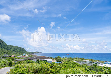 台灣台東蘭嶼風景:遠眺燕音族現代村落,碧藍的太平洋海景,廣闊的藍天,白雲朵朵,視野開闊。 台灣台東蘭嶼風景:遠眺燕音族現代村落,碧藍的太平洋海景,廣闊的藍天,白雲朵朵,視野開闊。 139804334