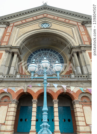 the soaring, symmetrical grandeur of Alexandra Palace historic Victorian facade, where a monumental central arch and an exquisite rose window dominate the structure. Anchoring the foreground is a 139804507