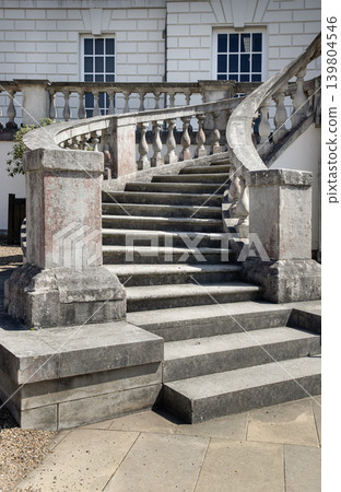 Defying the prevailing Tudor and Gothic trends of its time, the Palladian-inspired horseshoe staircase in front of the Queen House ascends gracefully toward a classical terrace. Its weathered stone Defying the prevailing Tudor and Gothic trends of its time, the Palladian-inspired horseshoe staircase in front of the Queen House ascends gracefully toward a classical terrace. Its weathered stone 139804546