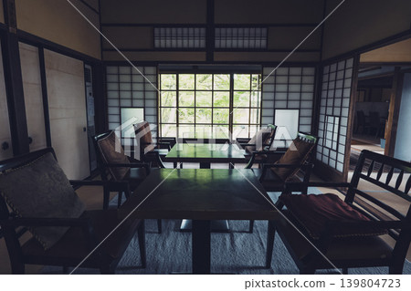 Soft light streams in through the shoji screens into the interior of the old house. Soft light streams in through the shoji screens into the interior of the old house. 139804723