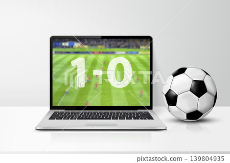 Laptop computer with live soccer match score on the screen and soccer ball on table Laptop computer with live soccer match score on the screen and soccer ball on table 139804935