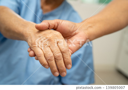 Caregiver holding hands Asian elderly woman patient, help and care in hospital. Caregiver holding hands Asian elderly woman patient, help and care in hospital. 139805007