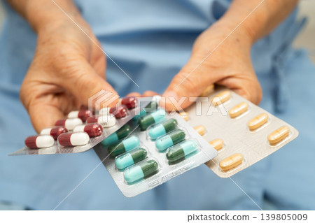 Asian elderly woman holding pill drug in hand, strong healthy medical. Asian elderly woman holding pill drug in hand, strong healthy medical. 139805009