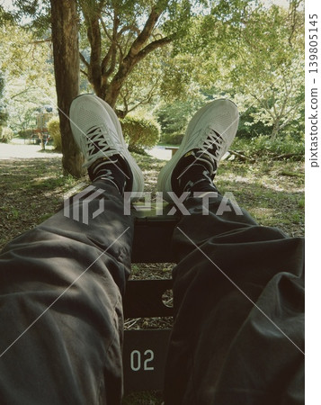 一名男子在露營地放鬆的雙腳:一名男子將雙腳放在貨櫃上放鬆的第一人稱視角。 一名男子在露營地放鬆的雙腳:一名男子將雙腳放在貨櫃上放鬆的第一人稱視角。 139805145