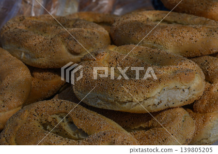 Freshly baked bagels piled high, showcasing their golden crusts and sprinkled toppings in a local bakery during the morning rush Freshly baked bagels piled high, showcasing their golden crusts and sprinkled toppings in a local bakery during the morning rush 139805205